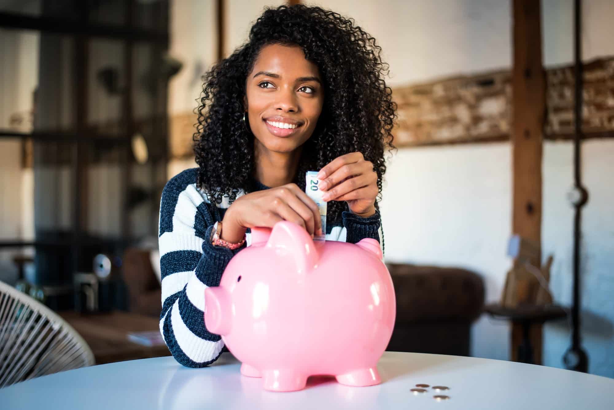 Black woman with saving piggy bank